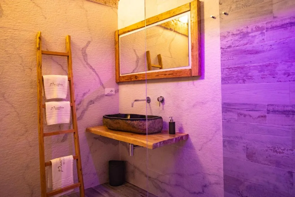 Stone vessel basin on a wooden shelf with mood lighting