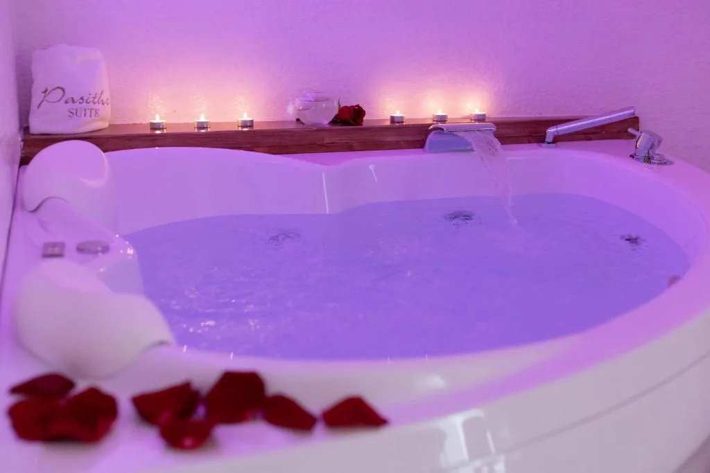 Heart-shaped whirlpool glowing with candles and rose petals