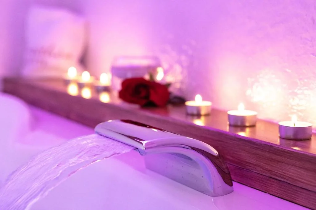 Waterfall whirlpool spout with candles and a rose